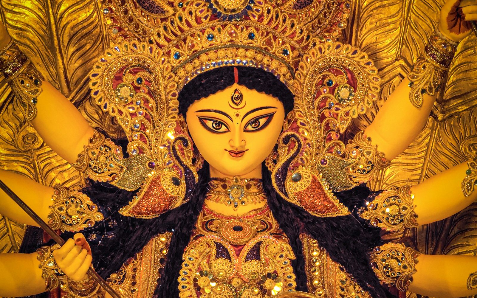 A golden Durga idol lit up inside a Kolkata pandal