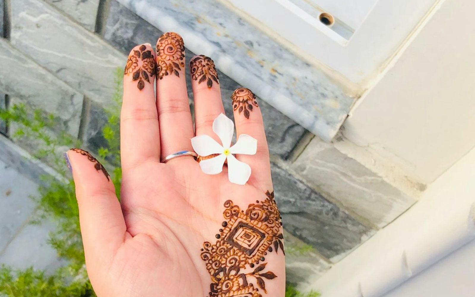 A hand decorated with fine mehndi patterns before Karwa Chauth